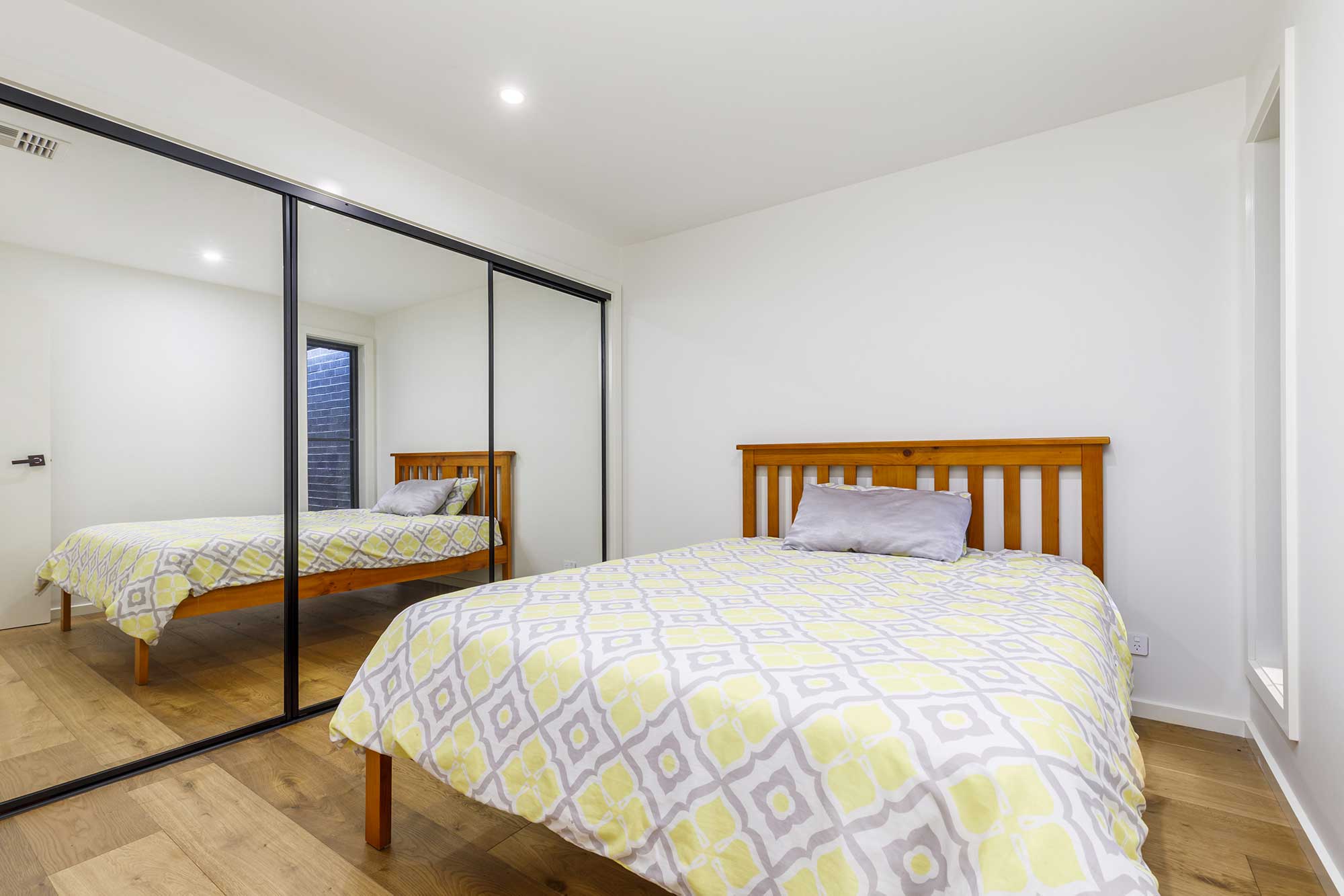 Bedroom with built-in mirrored wardrobe in a custom home build in Taylor, Canberra, completed by CanDo House.