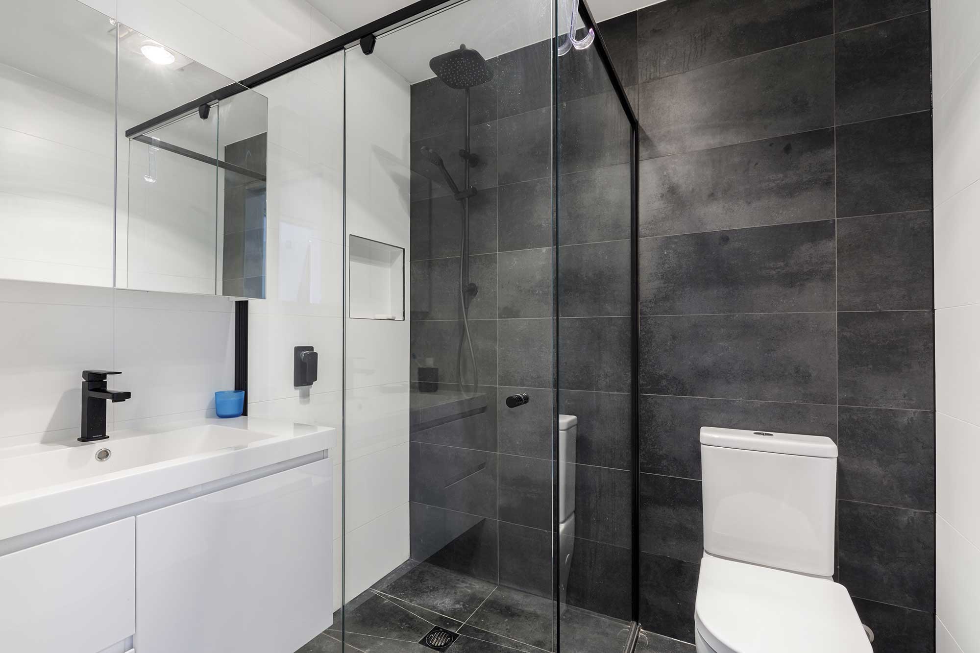 Modern bathroom with walk-in shower, black fixtures and contemporary tiling in a custom home build in Taylor, Canberra by CanDo House.