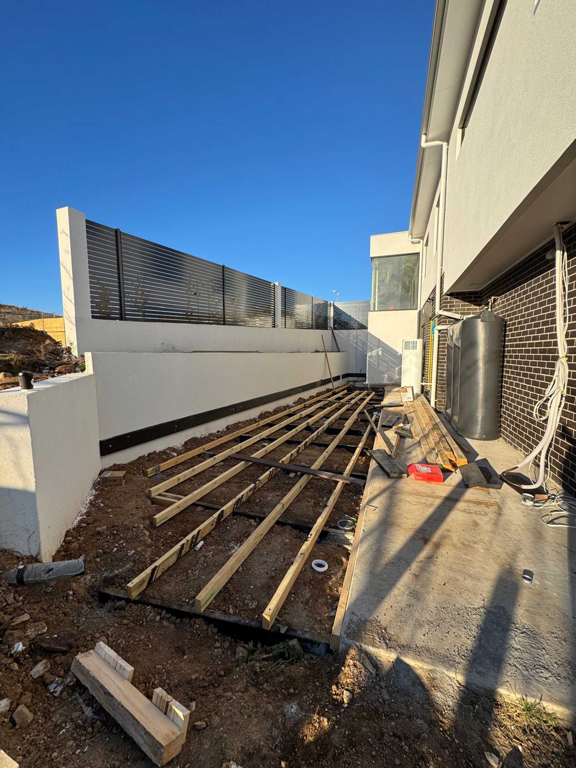 Composite decking with vertical cladding and custom bench seating in Whitlam