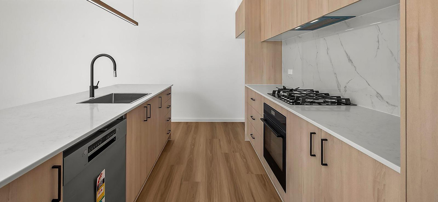 Custom kitchen joinery in Canberra by CanDo House featuring timber cabinetry, stone benchtops, and premium built-in appliances.