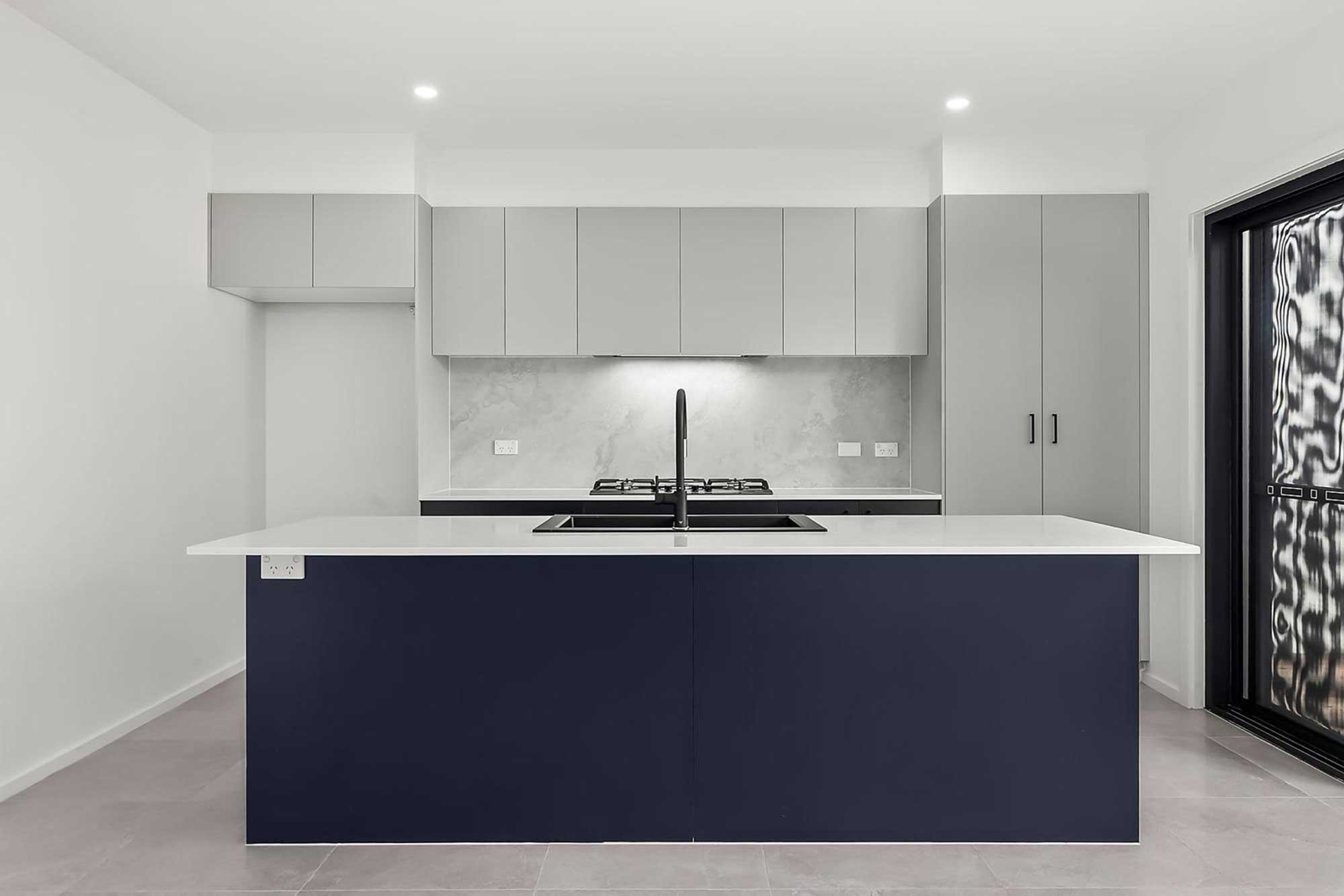 Custom kitchen joinery with navy cabinets and stone benchtops in Whitlam Canberra