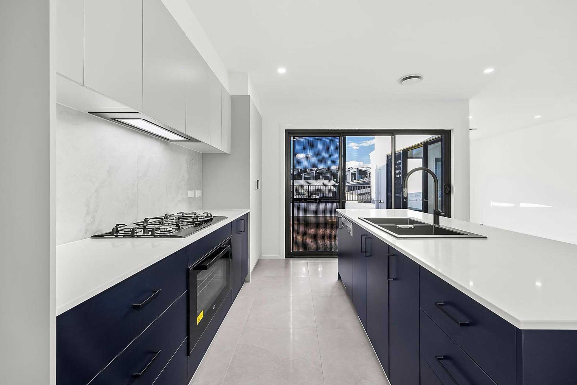 Contemporary kitchen design with navy cabinetry and stone countertops in Whitlam Canberra