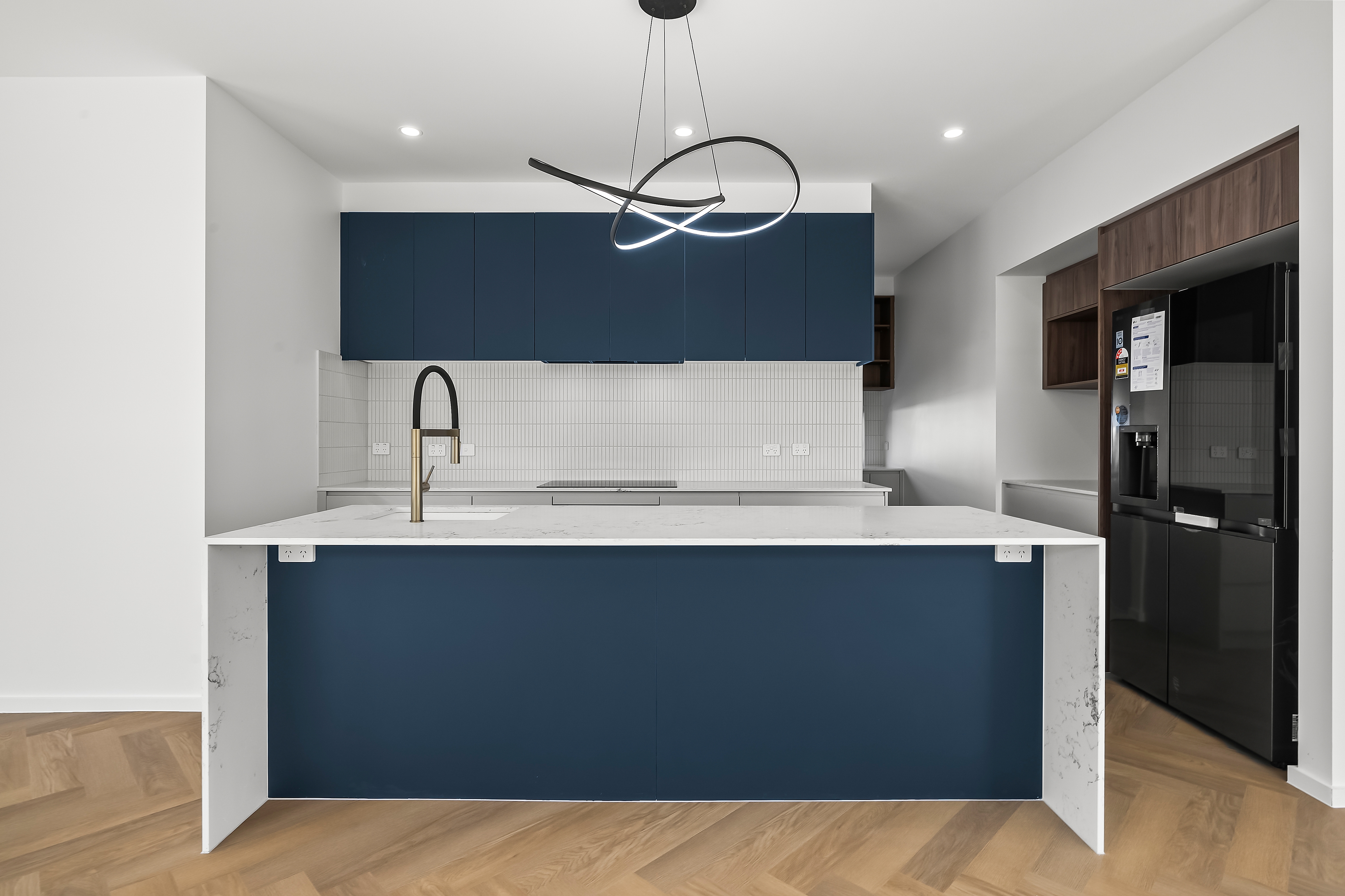 Custom kitchen joinery with navy cabinets and stone benchtops in Whitlam Canberra